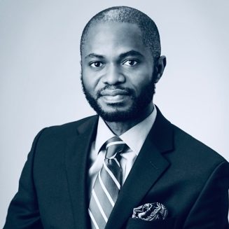 A person wearing a suit and tie smiling at the camera

Description automatically generated